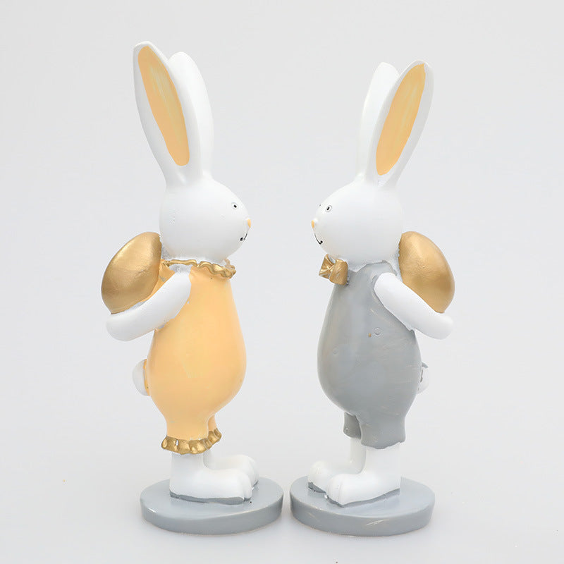 Coppia di decorazioni regalo con uova dorate e coniglietto pasquale