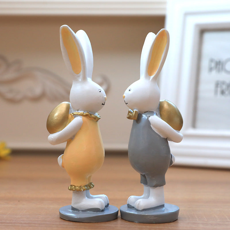 Coppia di decorazioni regalo con uova dorate e coniglietto pasquale